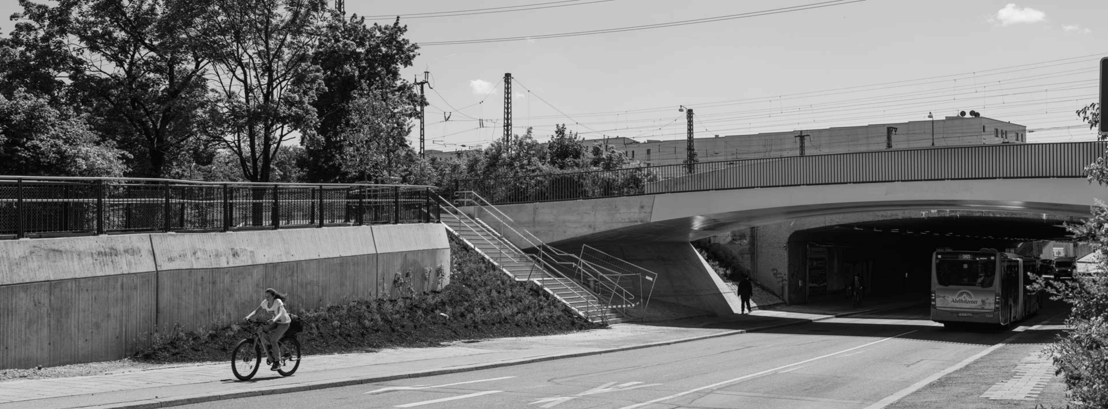 Aufnahme eines Busses von hinten, der unter der Brücke fährt.